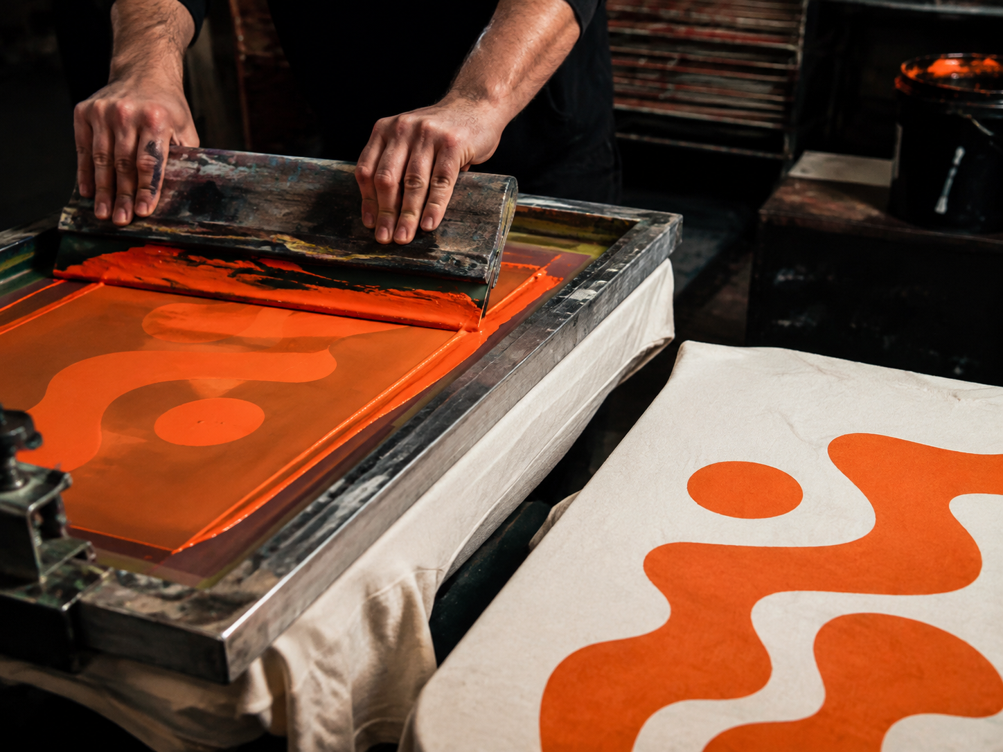 Proceso de serigrafía con tinta naranja sobre algodón