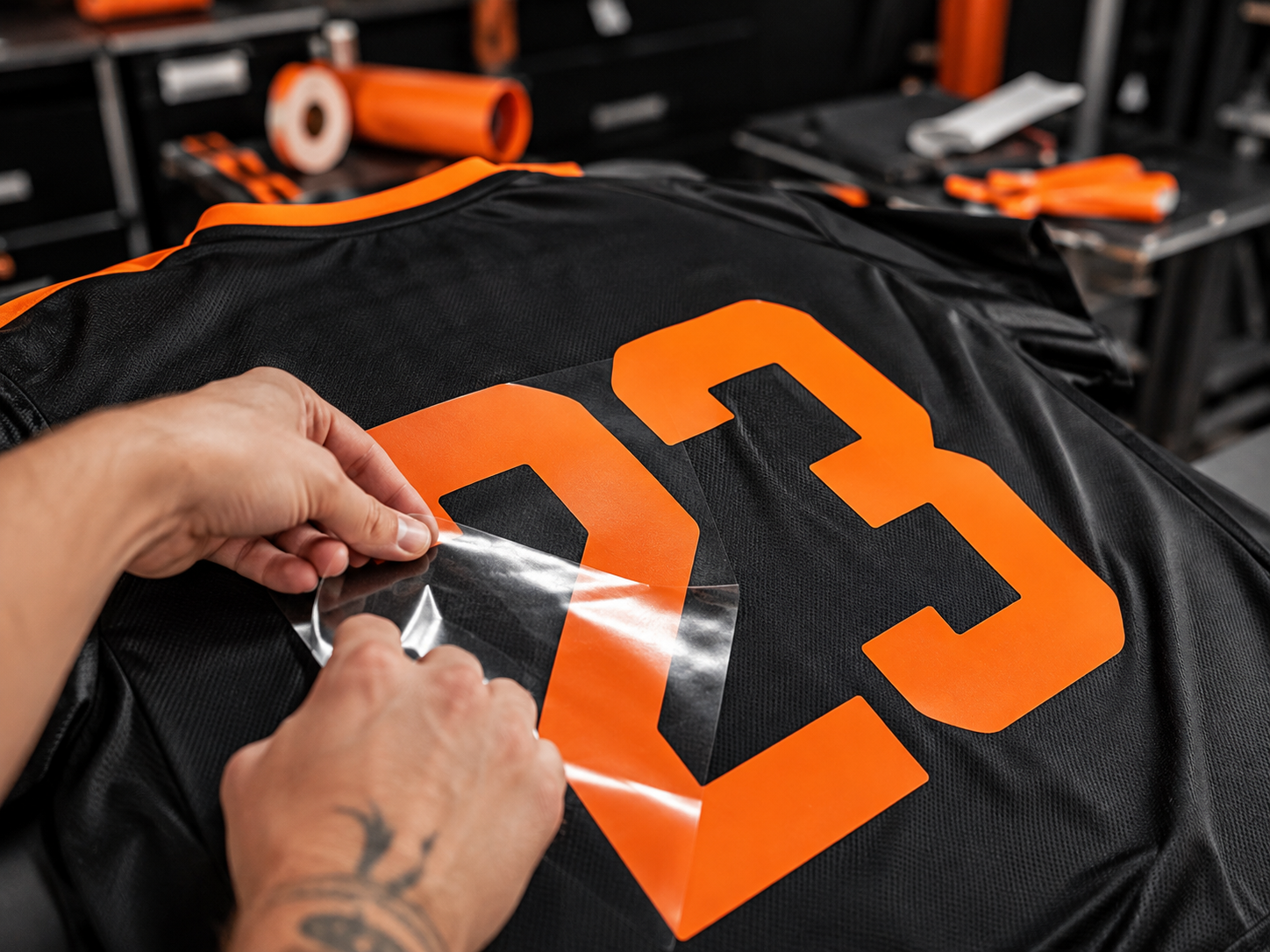 Vinilo naranja aplicado sobre una camiseta deportiva negra